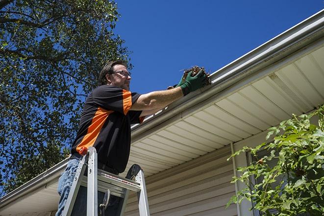 an experienced worker repairing a gutter on a house in Fairfax, IA